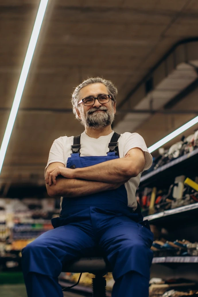 Mature man worker posing in hardware store aisle