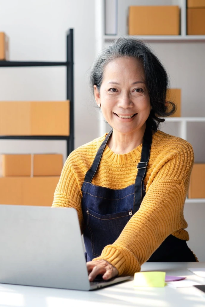 Woman working on laptop with boxes in background