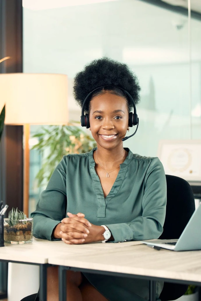 Portrait of a young businesswoman wearing a headset while working in an office