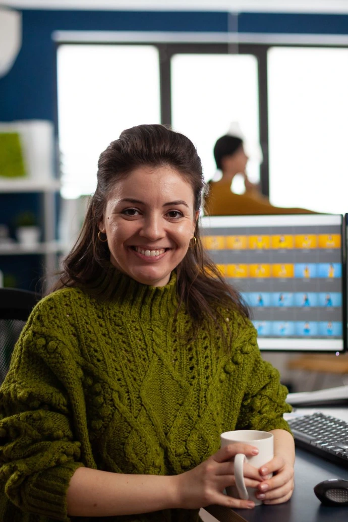 Woman retoucher looking at camera smiling sitting in creative design media agency